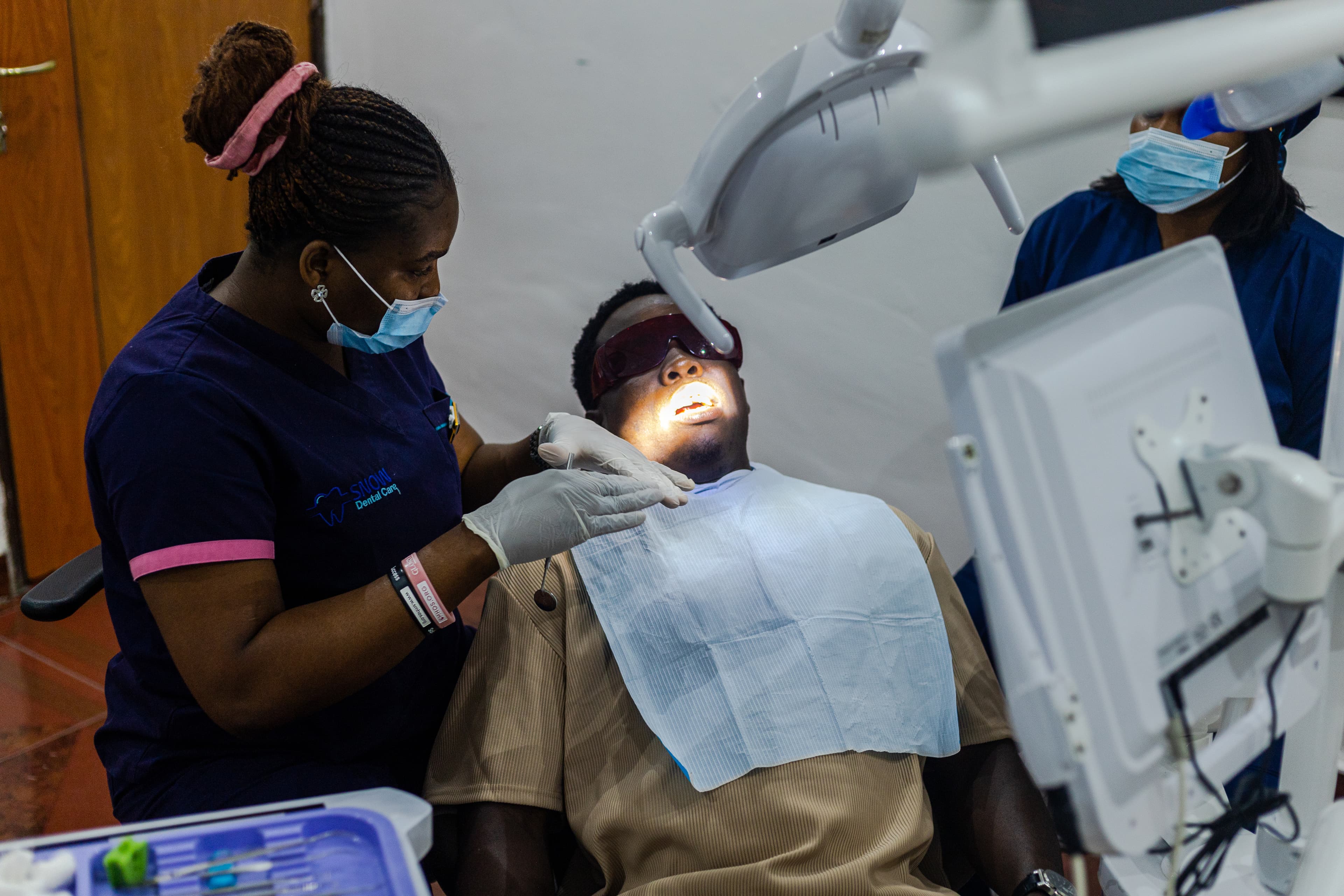 Dr. Favour Monday conducting a dental checkup at Snow Dental Care